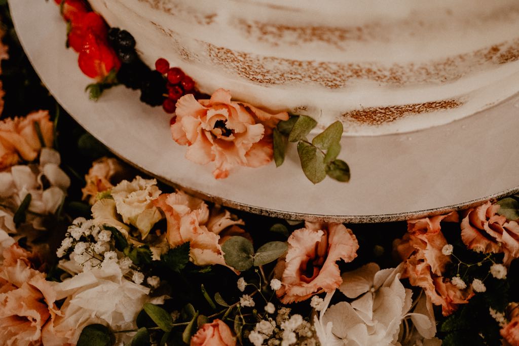 A naked three-tier wedding cake decorated with roses, torta di matrimonio a Matera,