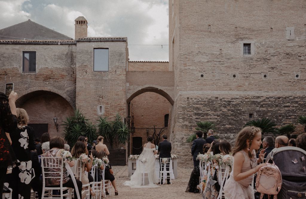 Gli sposi, insieme agli invitati durante il rito civile nella Corte del Castello di San Basilio, servizio fotografico di Matrimonio