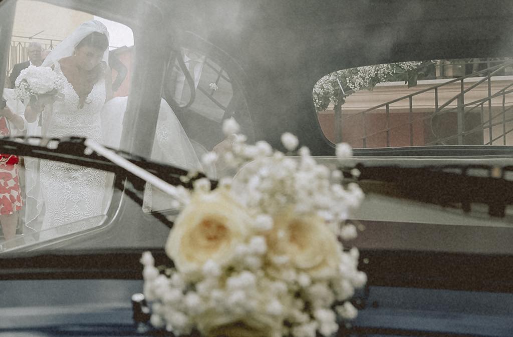 la sposa attinge a salire in macchina, inquadratura cinematografica di un reportage di matrimonio in Basilicata, Maratea
