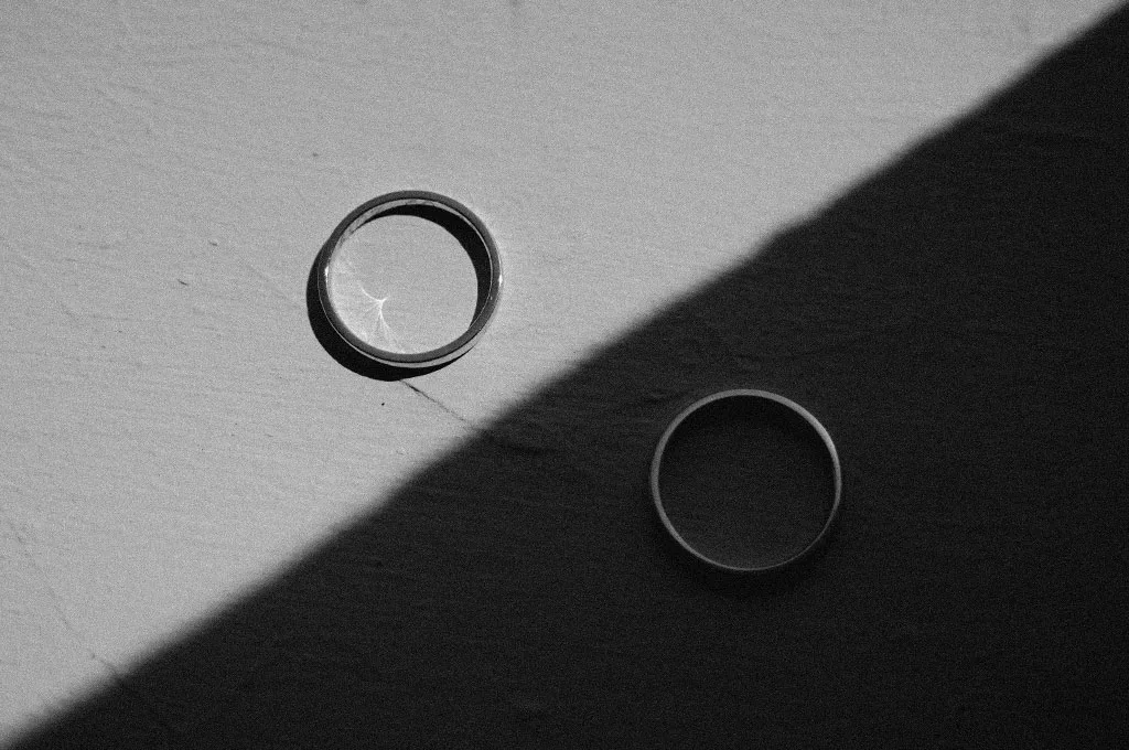 dettaglio delle fedi in una fotografia in bianco e nero con forti giochi di luci e ombre in un caldo giorno a Maratea durante un matrimonio all'Hotel Santa Venere