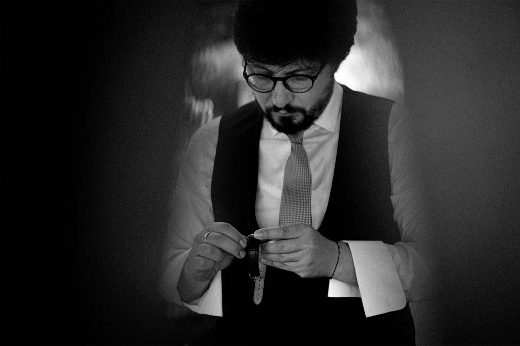 Fotografia in bianco e nero dello sposo che controlla l'orologio durante il suo Matrimonio a Maratea nella Villa La Matrella